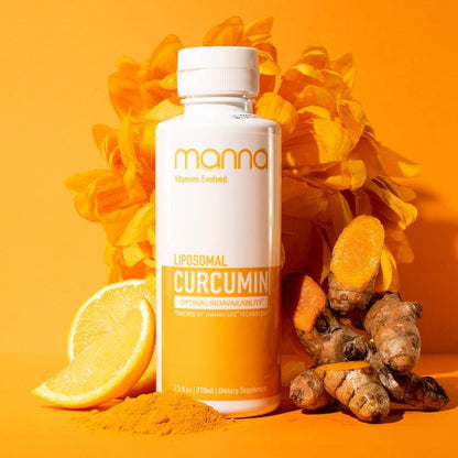 Bottle of Manna Curcumin supplement with turmeric roots, lemon, and flowers on an orange background